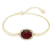 Gold bracelet with oval garnet gemstone and clear stone border