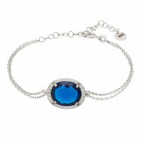 Silver oval gemstone bracelet with blue center stone and halo detail