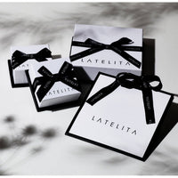 Assorted jewelry gift boxes with black bows and white tags