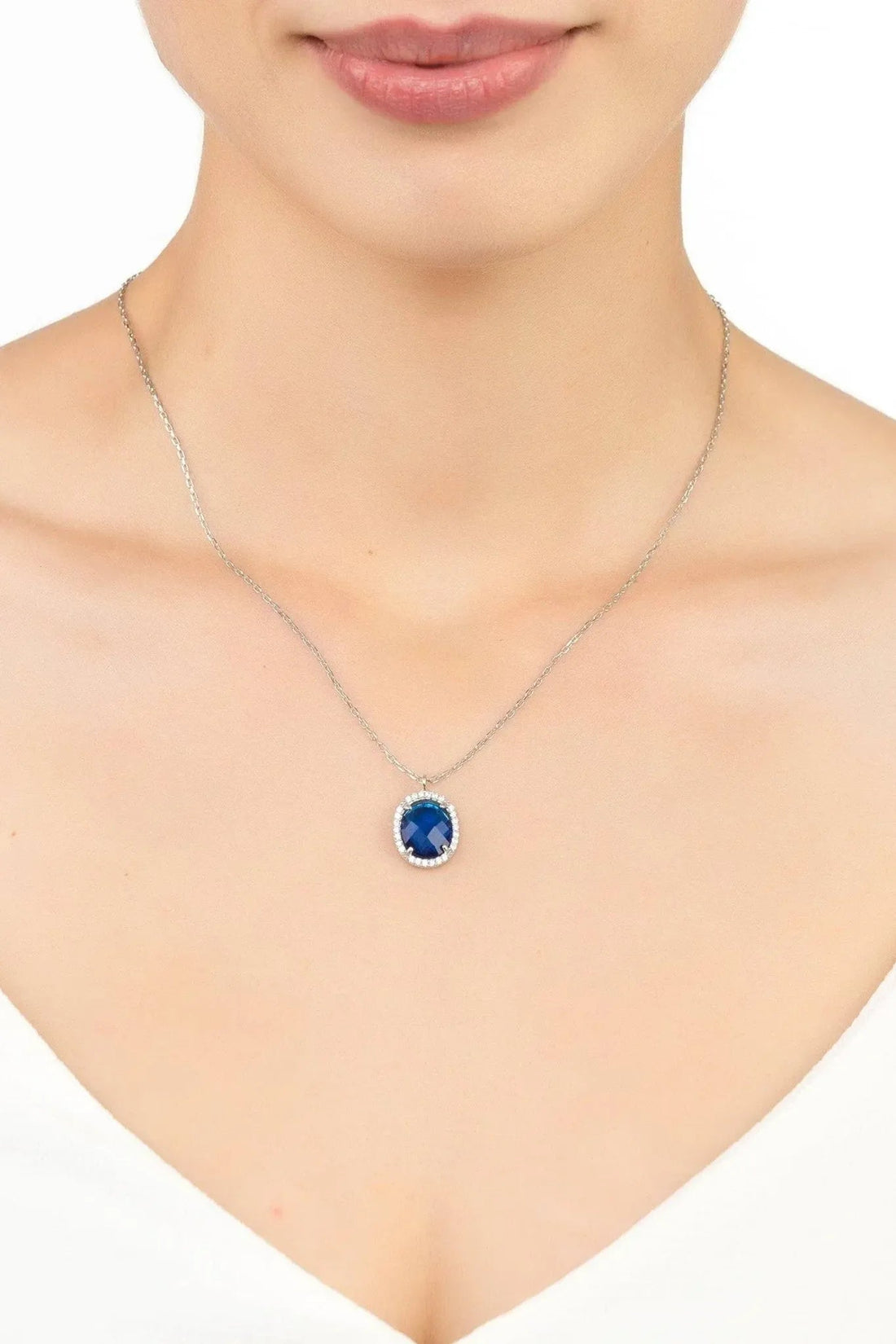 Silver chain necklace with small oval blue gemstone pendant
