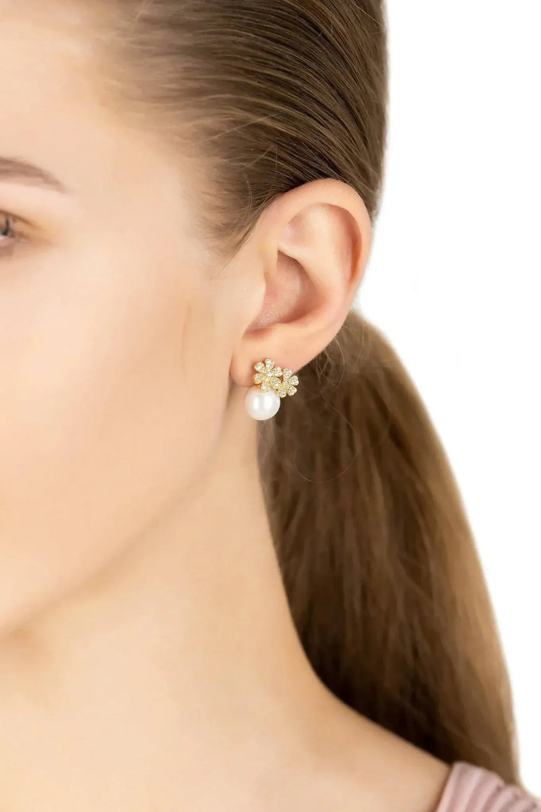 Gold-tone floral stud earrings with crystal details and a round pearl