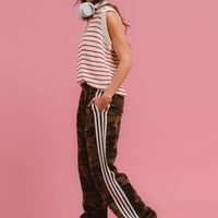Camouflage track pants with white stripe along the leg and tapered cuffed hems.