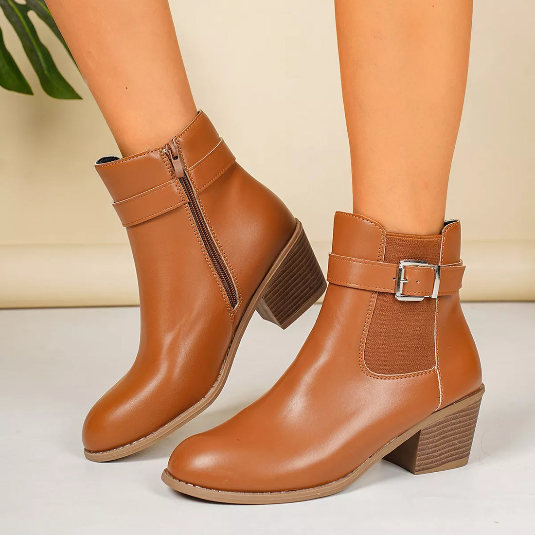 Brown point-toe block heel ankle boots with buckle strap and side zipper