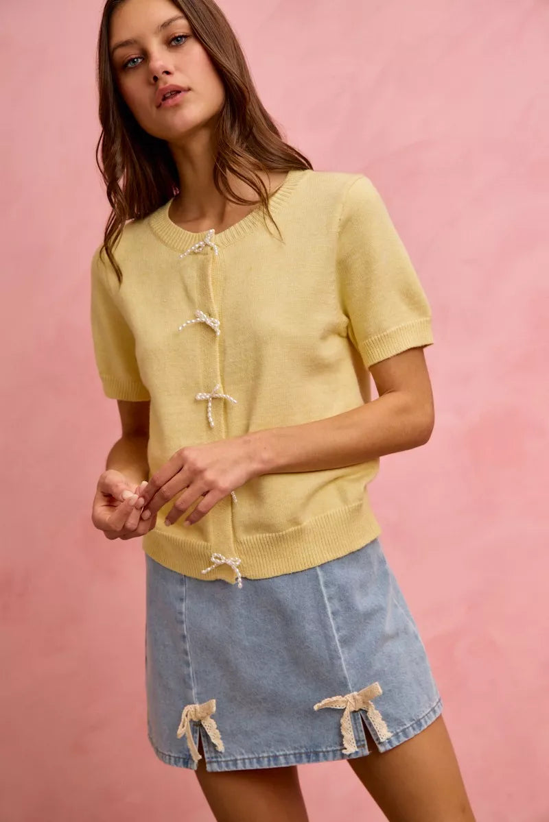 Light blue denim mini skirt with lace ribbon bow accents at the hem.