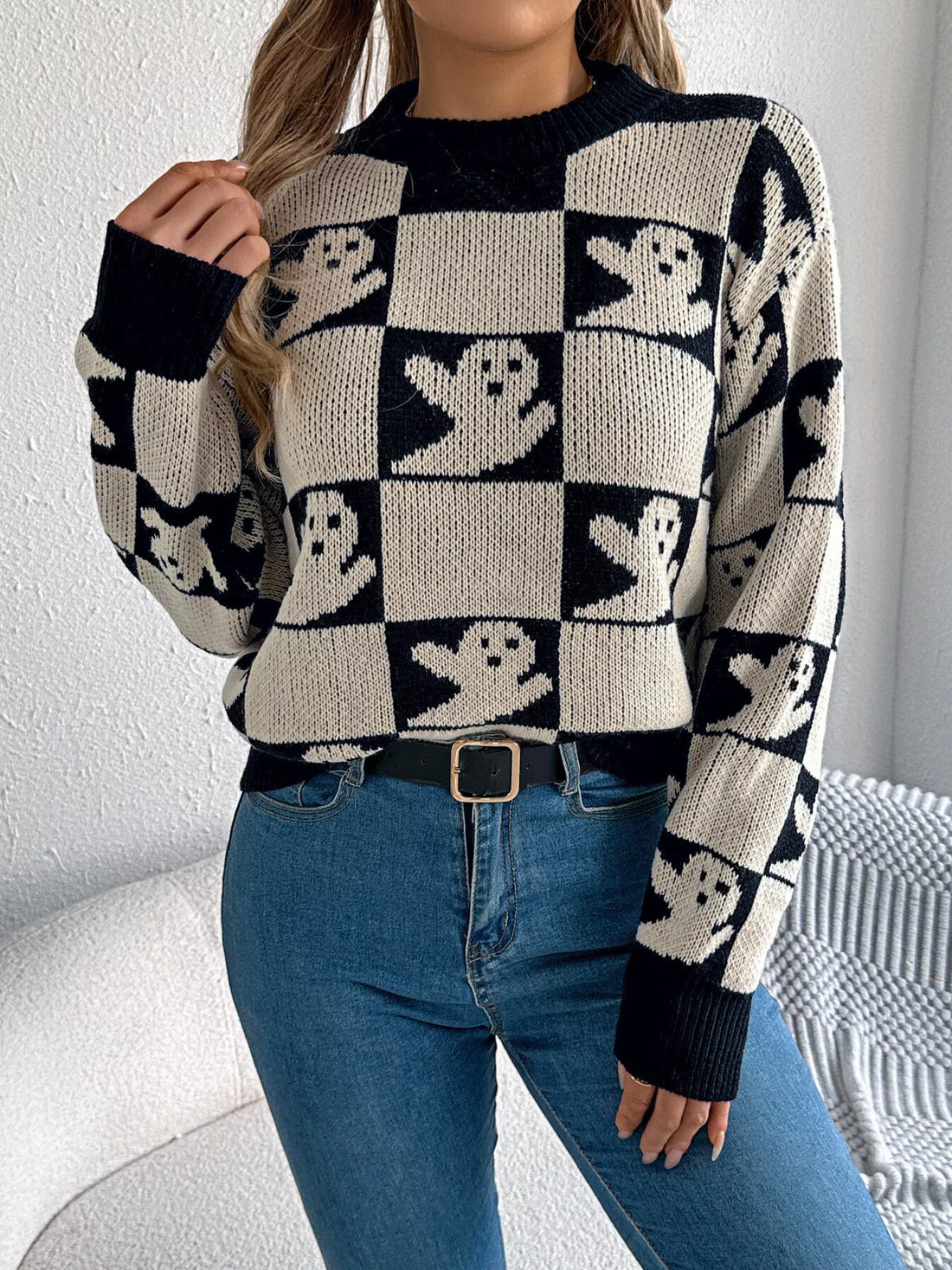 Ghost-pattern checkered round-neck sweater in black and cream with long sleeves.