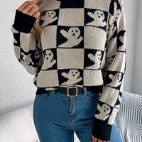 Ghost-pattern checkered round-neck sweater in black and cream with long sleeves.