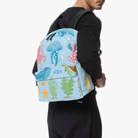 Kids canvas backpack worn on front, blue sea creature print with black shoulder straps.