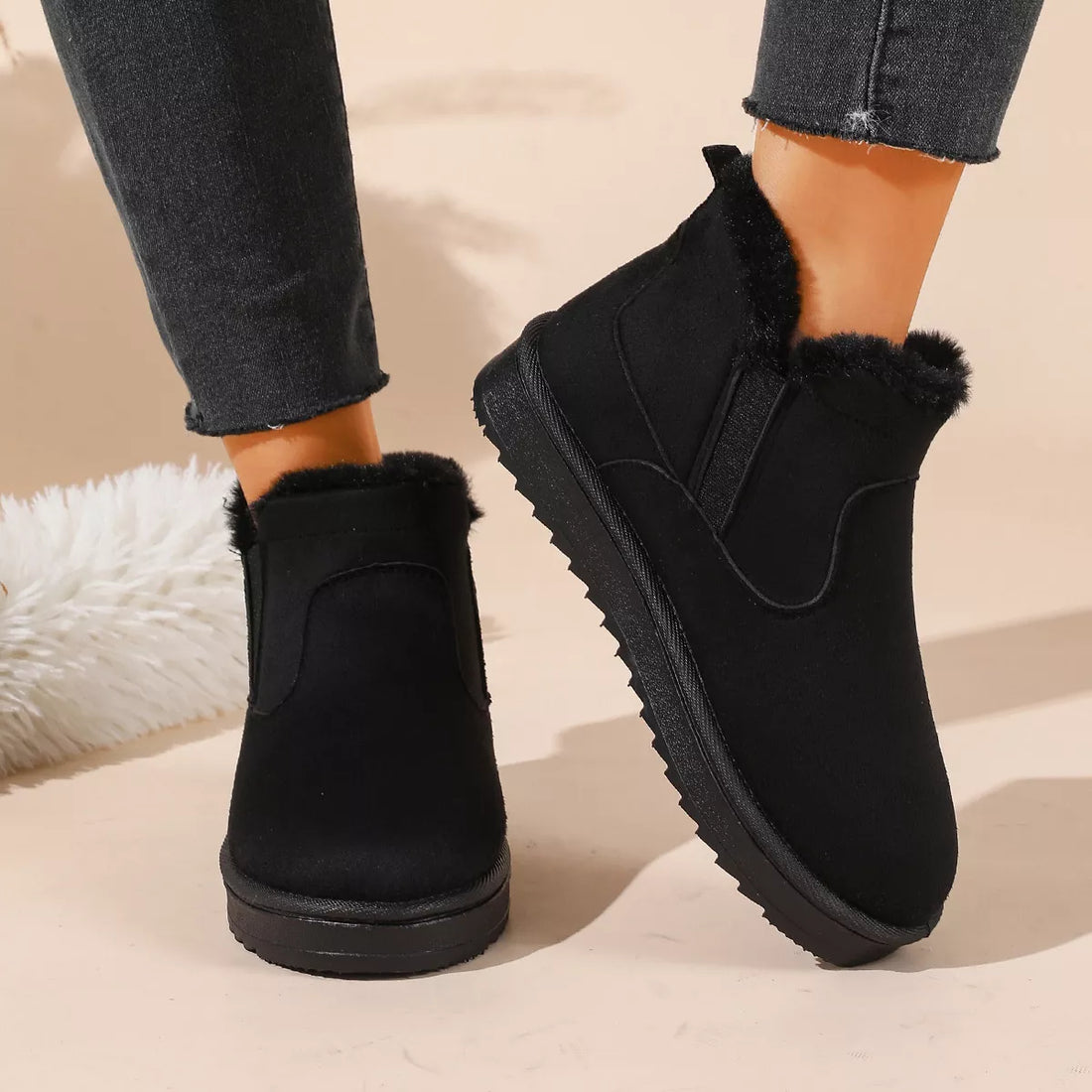 Black ankle boots with faux fur trim, side elastic gore, and chunky outsole