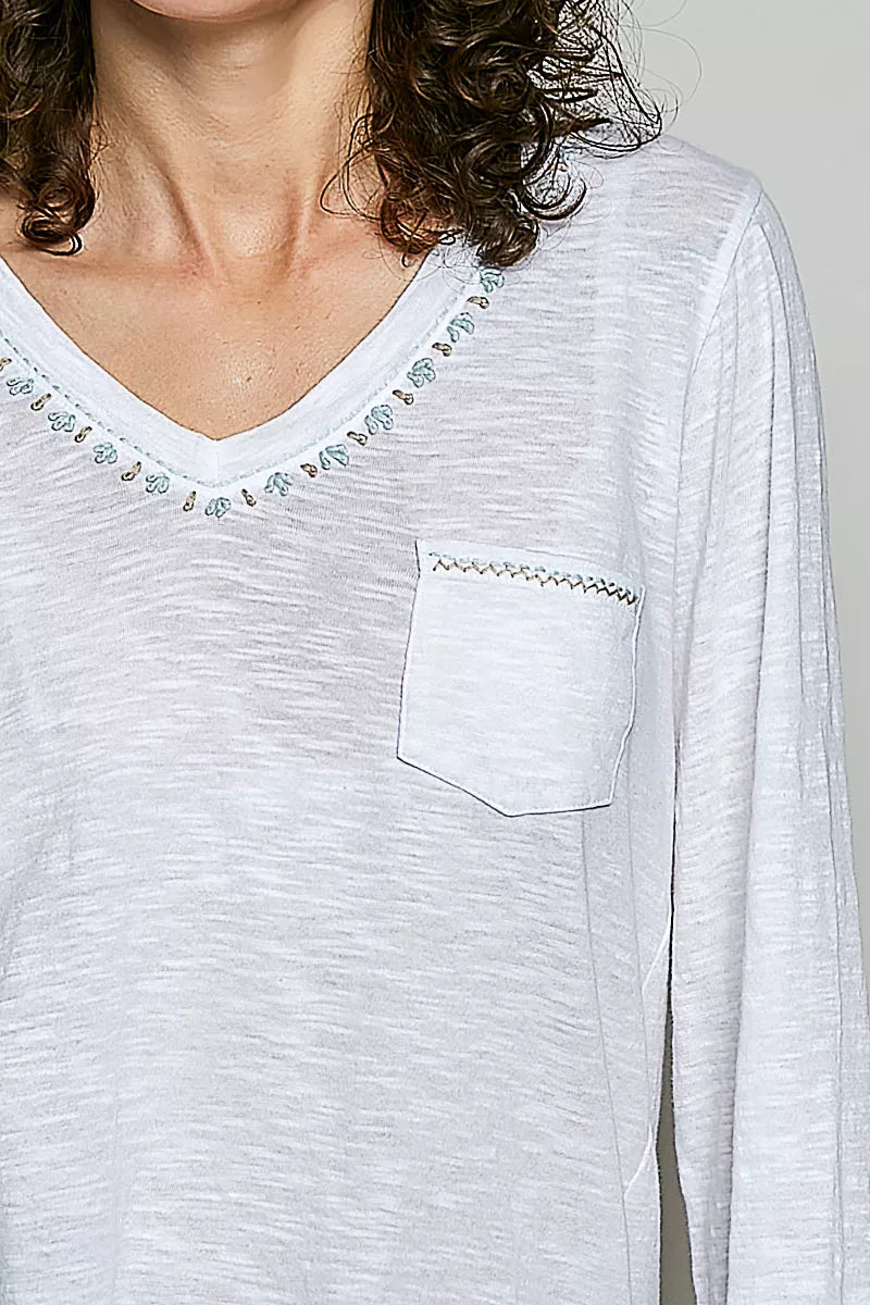 Off white V-neck knit top detail with contrast hand-stitched trim and chest pocket.