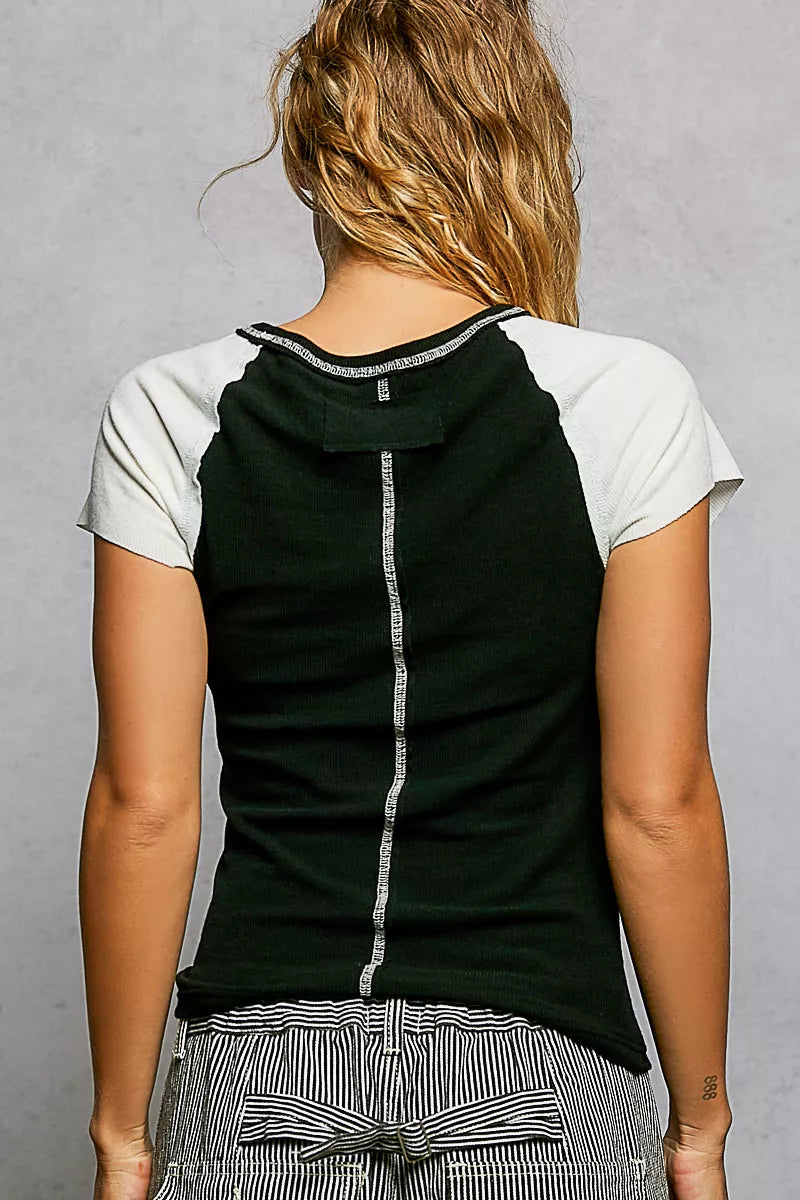 Black back of round-neck T-shirt with ivory contrast sleeves and outseam detail