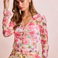 Pink multi floral mesh cardigan top with V-neckline, button front, and ruffled sleeves
