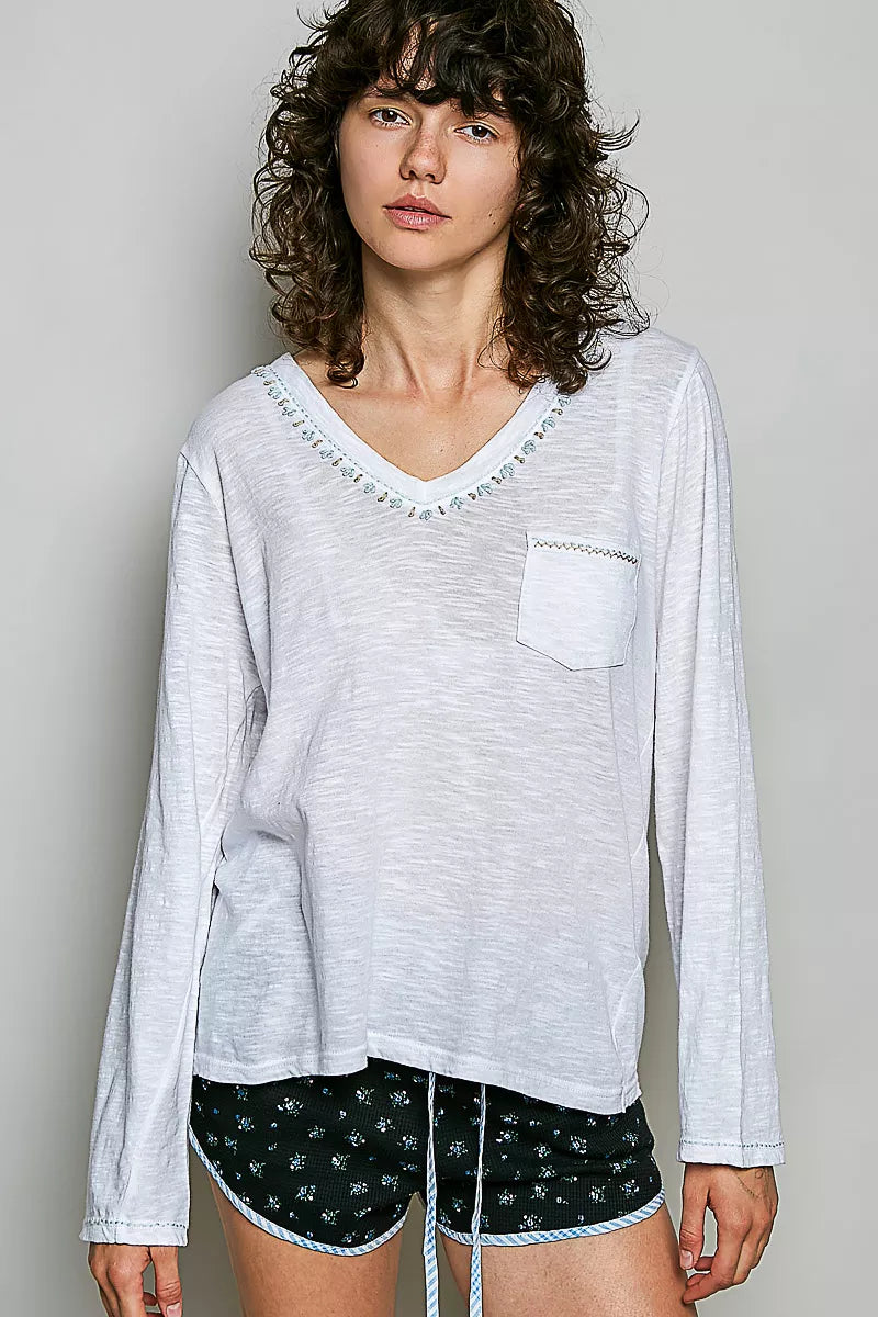 Off white V-neck long-sleeve knit top with contrast hand-stitched trim and chest pocket.