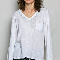 Off white V-neck long-sleeve knit top with contrast hand-stitched trim and chest pocket.