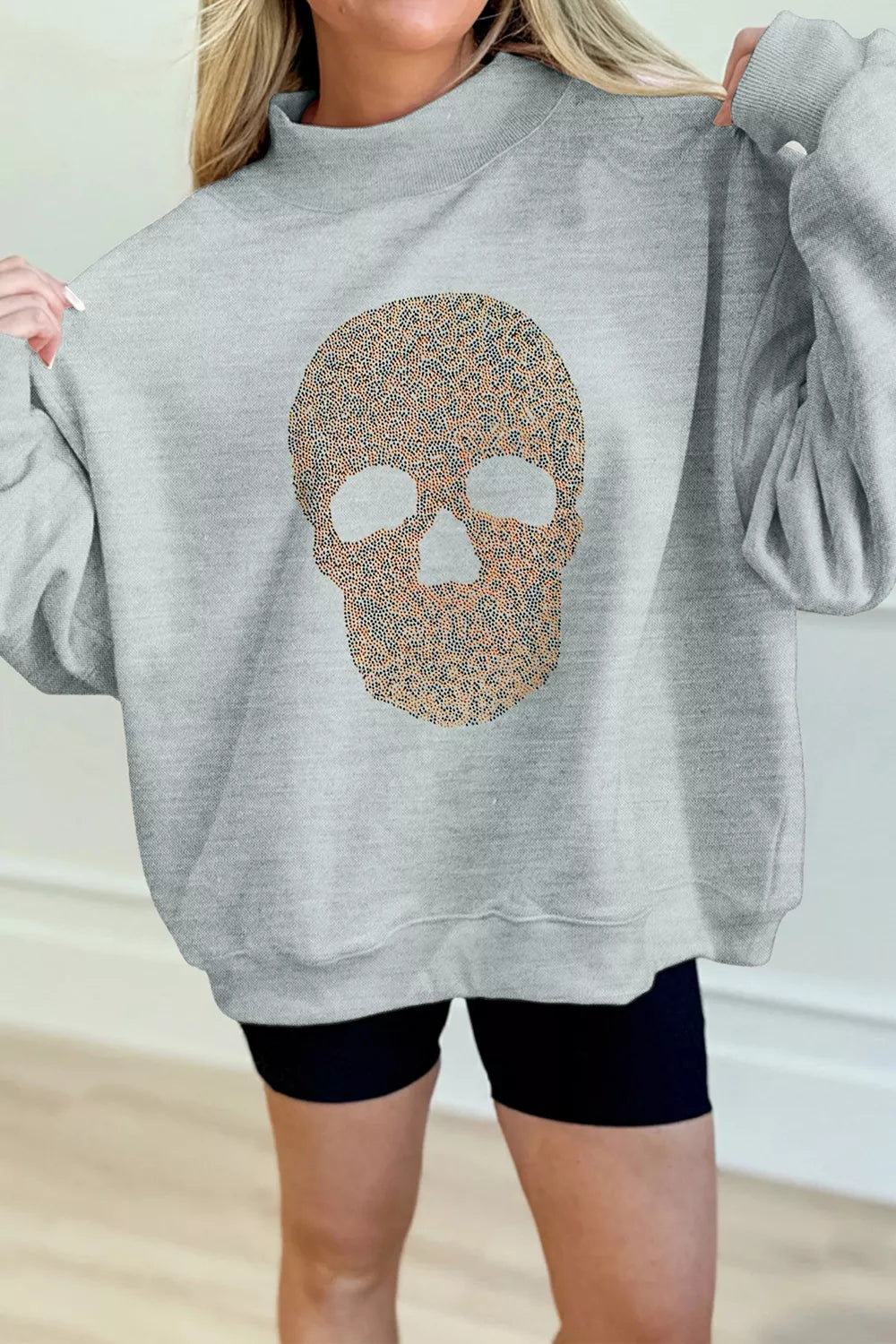 Gray loose-fit mock-neck pullover sweatshirt with rhinestone-style skull graphic