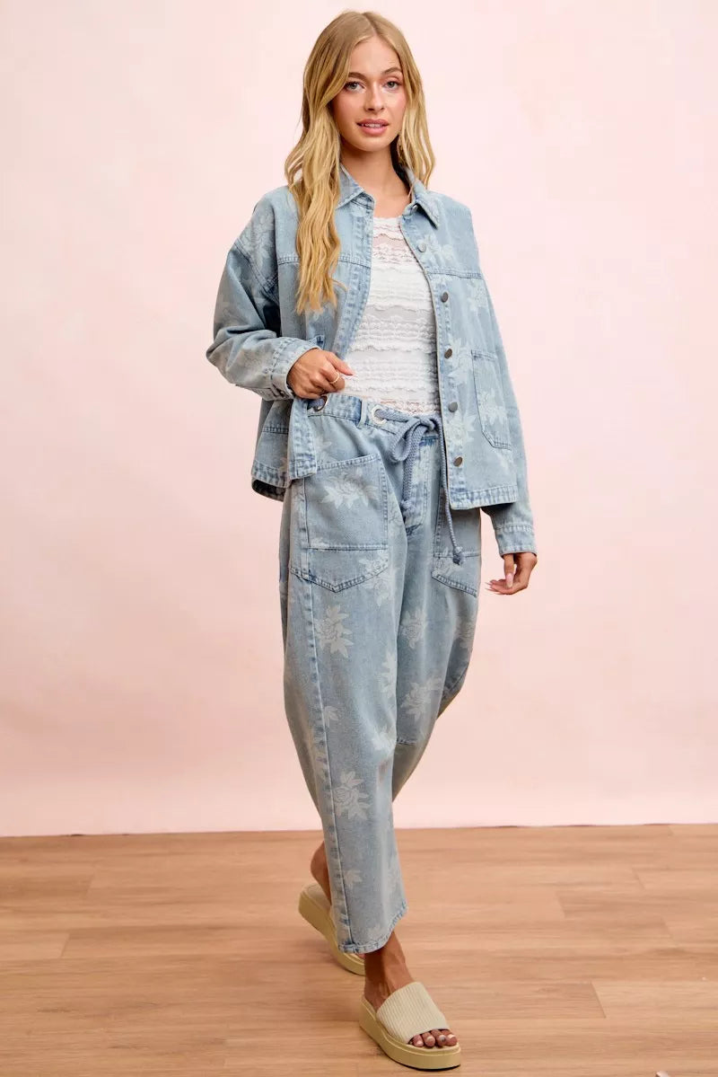 Light blue denim jacket with white floral print and front pockets, worn with matching pants