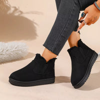 Black plush-lined ankle boots with side gore, fur trim, and grippy sole