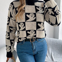 Ghost-pattern checkered round-neck sweater in black and cream, ribbed cuffs and hem.