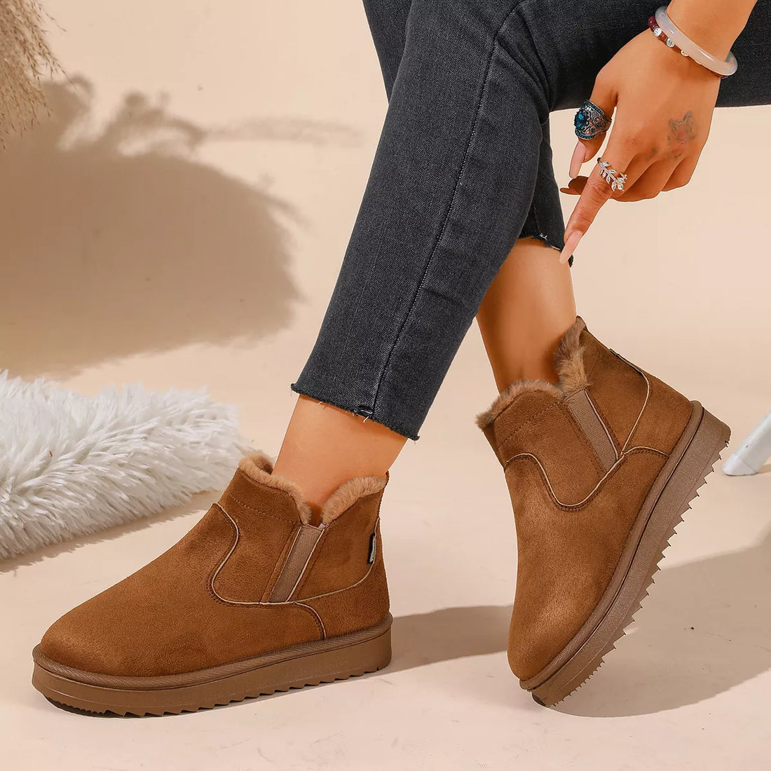 Tan plush-lined ankle boots with side elastic panels, faux fur lining, and flat sole