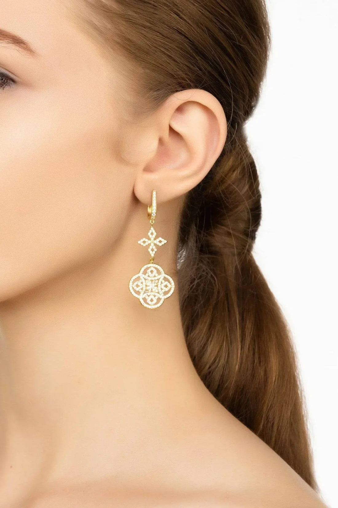 Gold Celtic knot clover drop earring worn on the ear