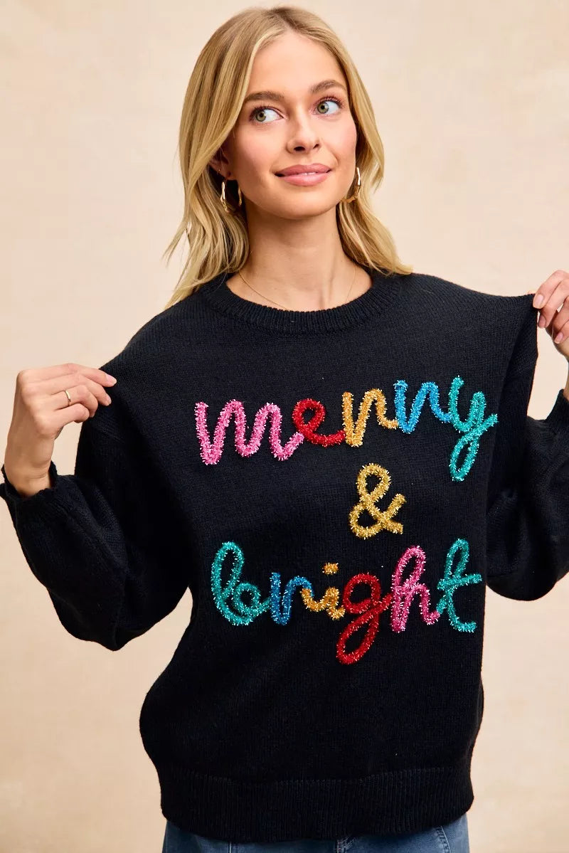 Black pullover sweater with multicolor tinsel "Merry & Bright" graphic on front