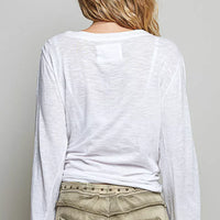 Off white long-sleeve knit top from back view with center yoke patch.