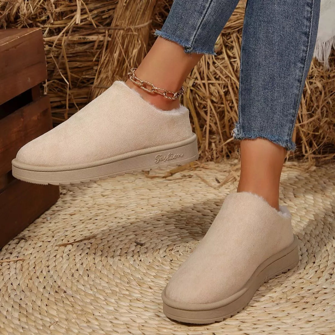 Off-white plush lined ankle boots with round toe, front view and low rubber outsole.