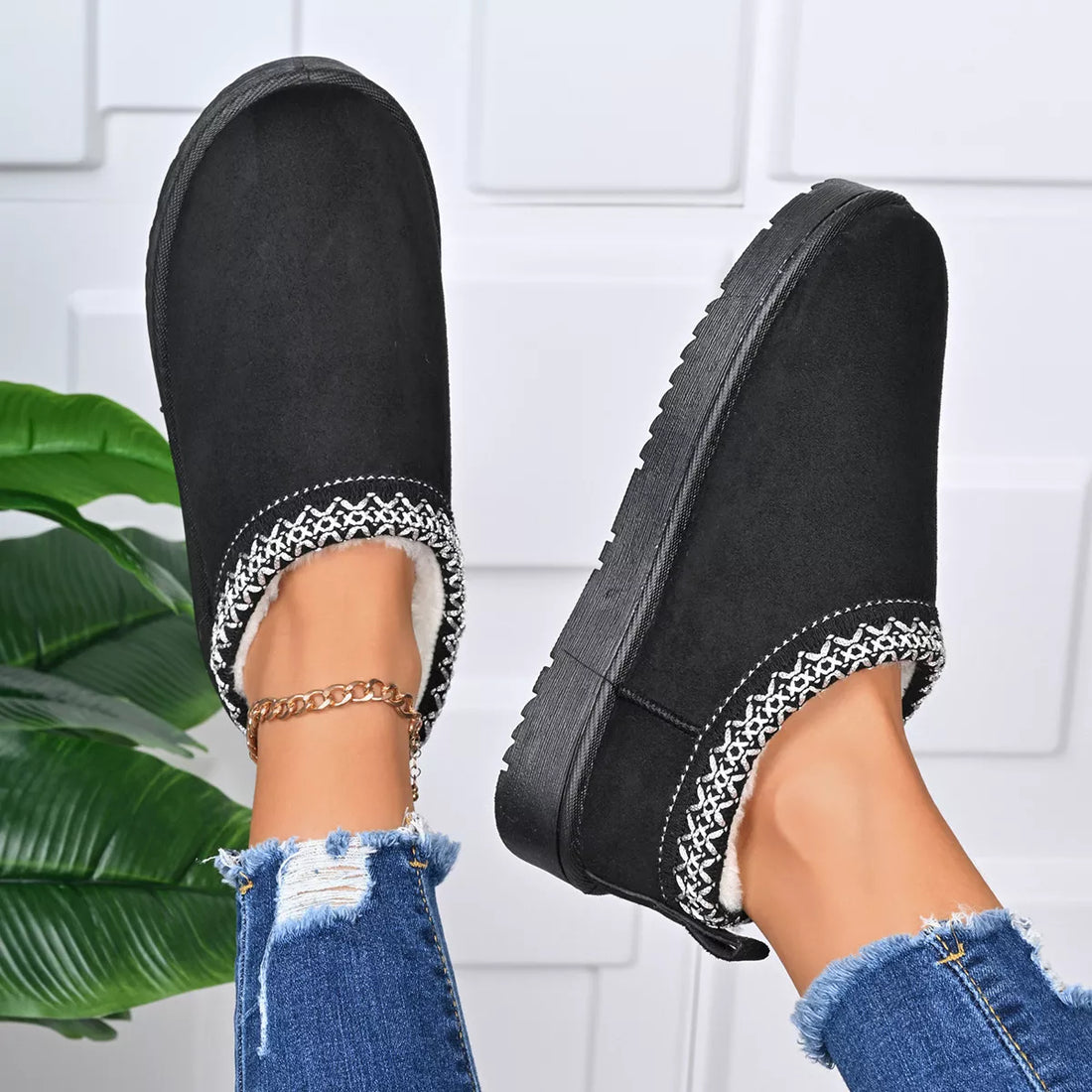 Black platform ankle boots with patterned trim and gold chain ankle bracelet