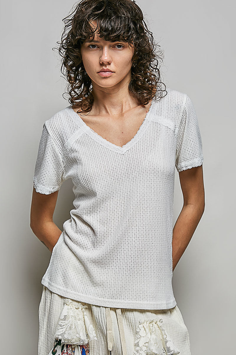 Off-white textured V-neck short-sleeve t-shirt, worn with ruffled skirt