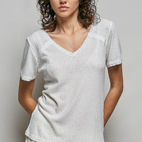 Off-white textured V-neck short-sleeve t-shirt, worn with ruffled skirt