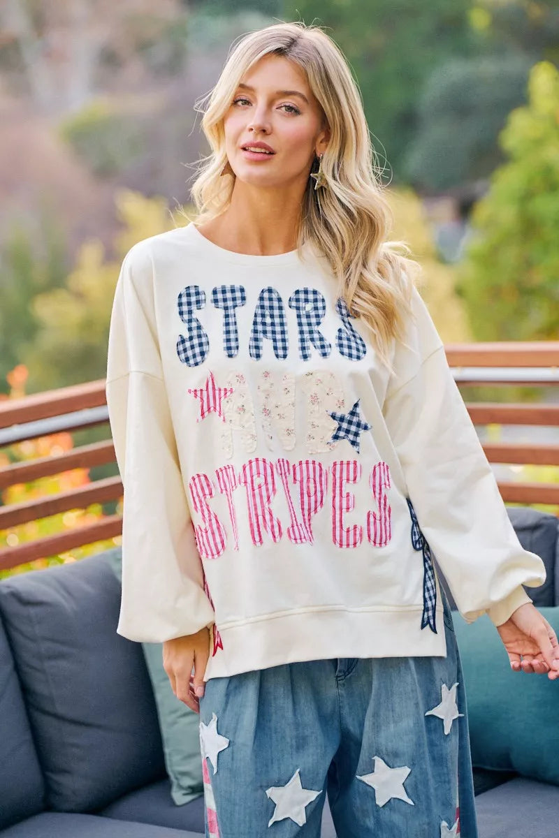 Cream crewneck sweatshirt with stars-and-stripes patch-style graphic, long sleeves