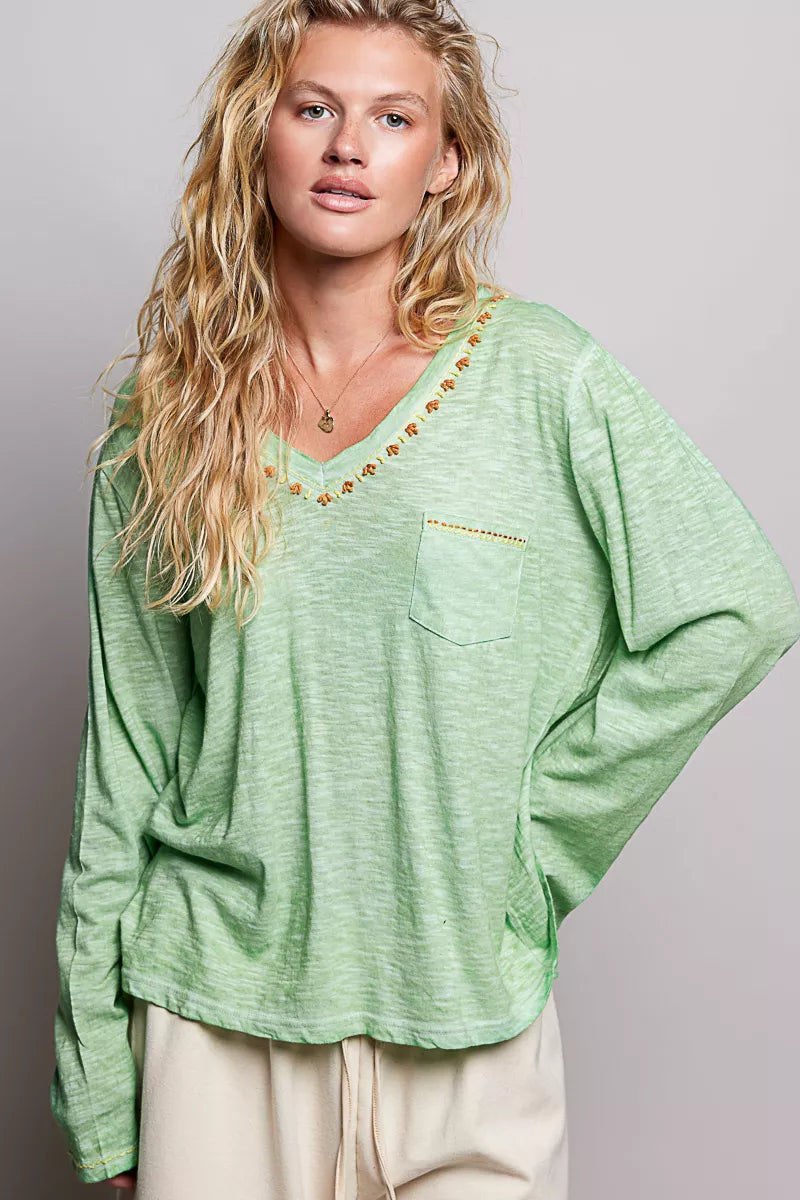 Light green V-neck knit top with embroidered neckline trim and front pocket