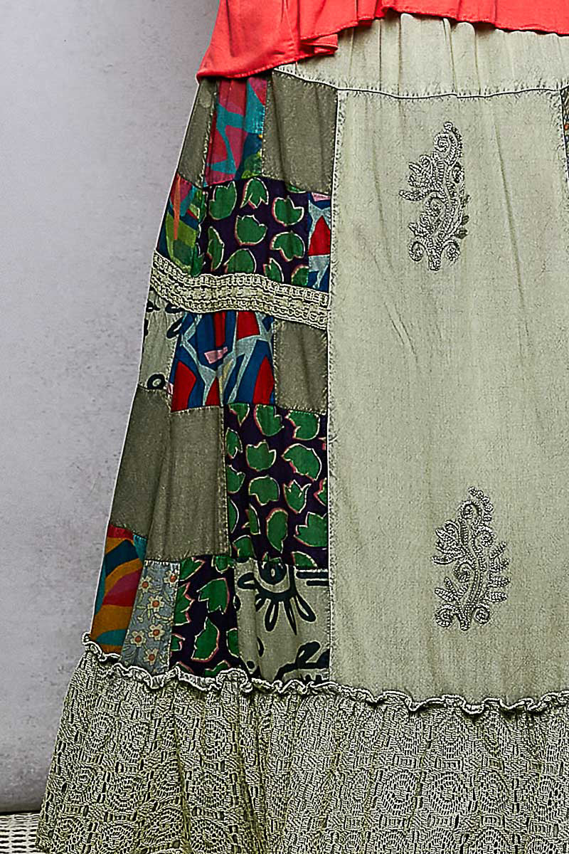 Close-up patchwork ruffled skirt panel with embroidered scrollwork and trims