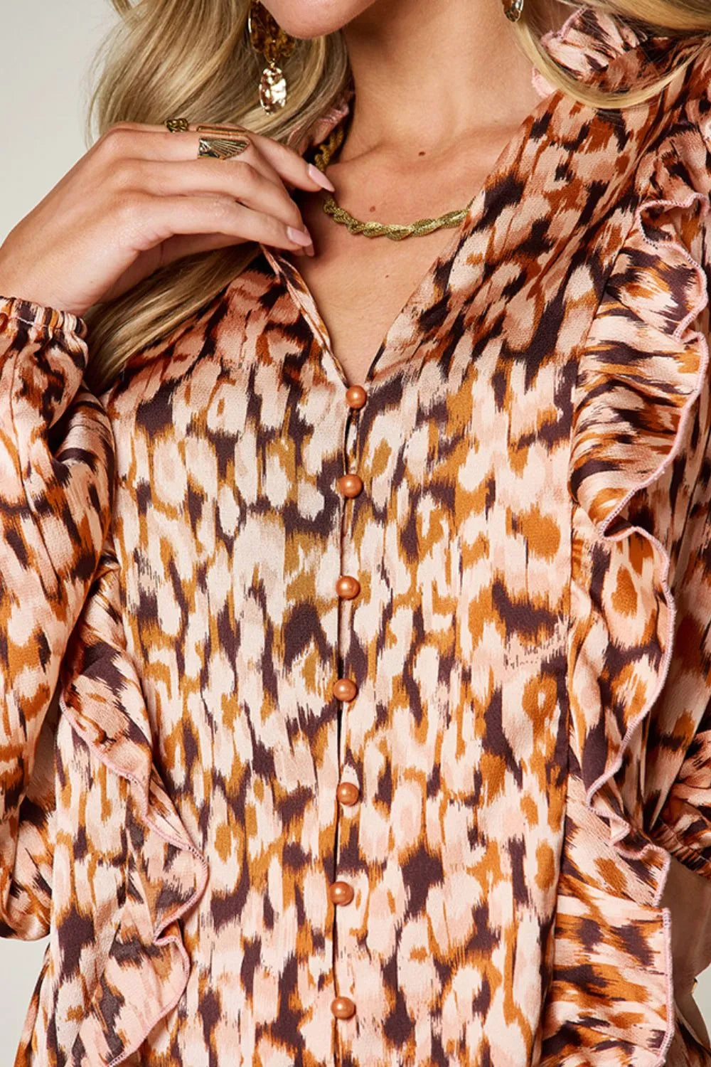 Caramel printed shirt close-up: ruffle-trim shoulders and button-front detail