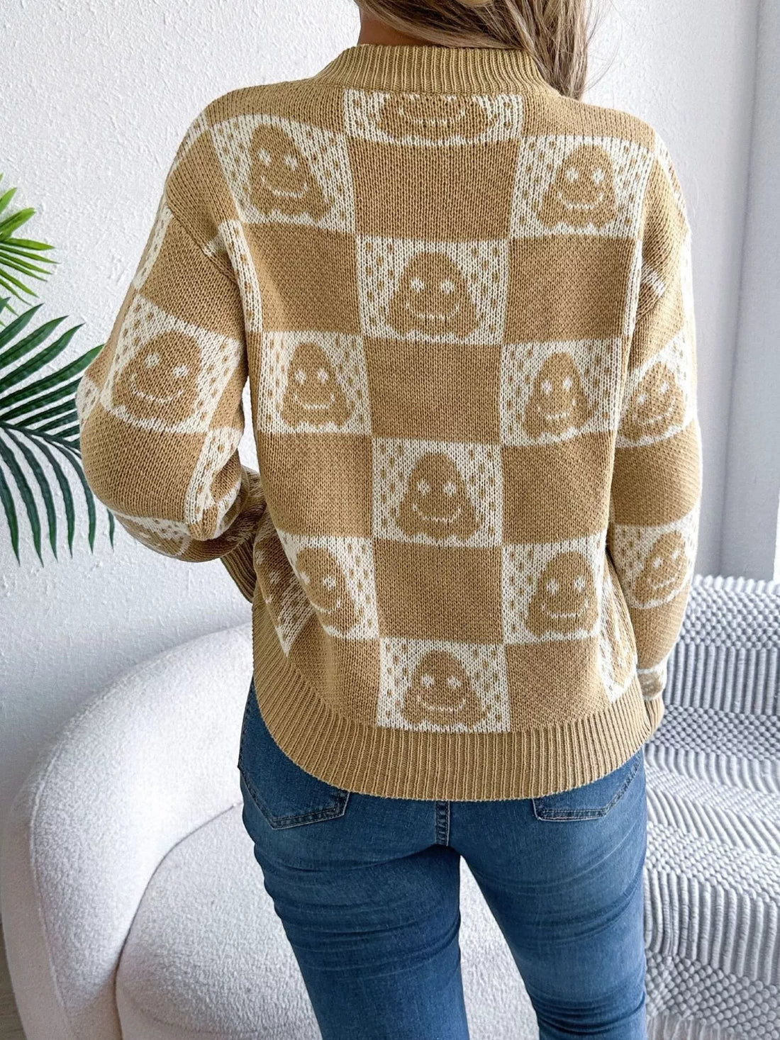 Back view of ghost-pattern checkered round-neck sweater in tan and cream.