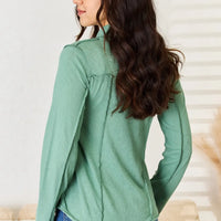 Emerald green long sleeve knit top with mock neck and side exposed seam