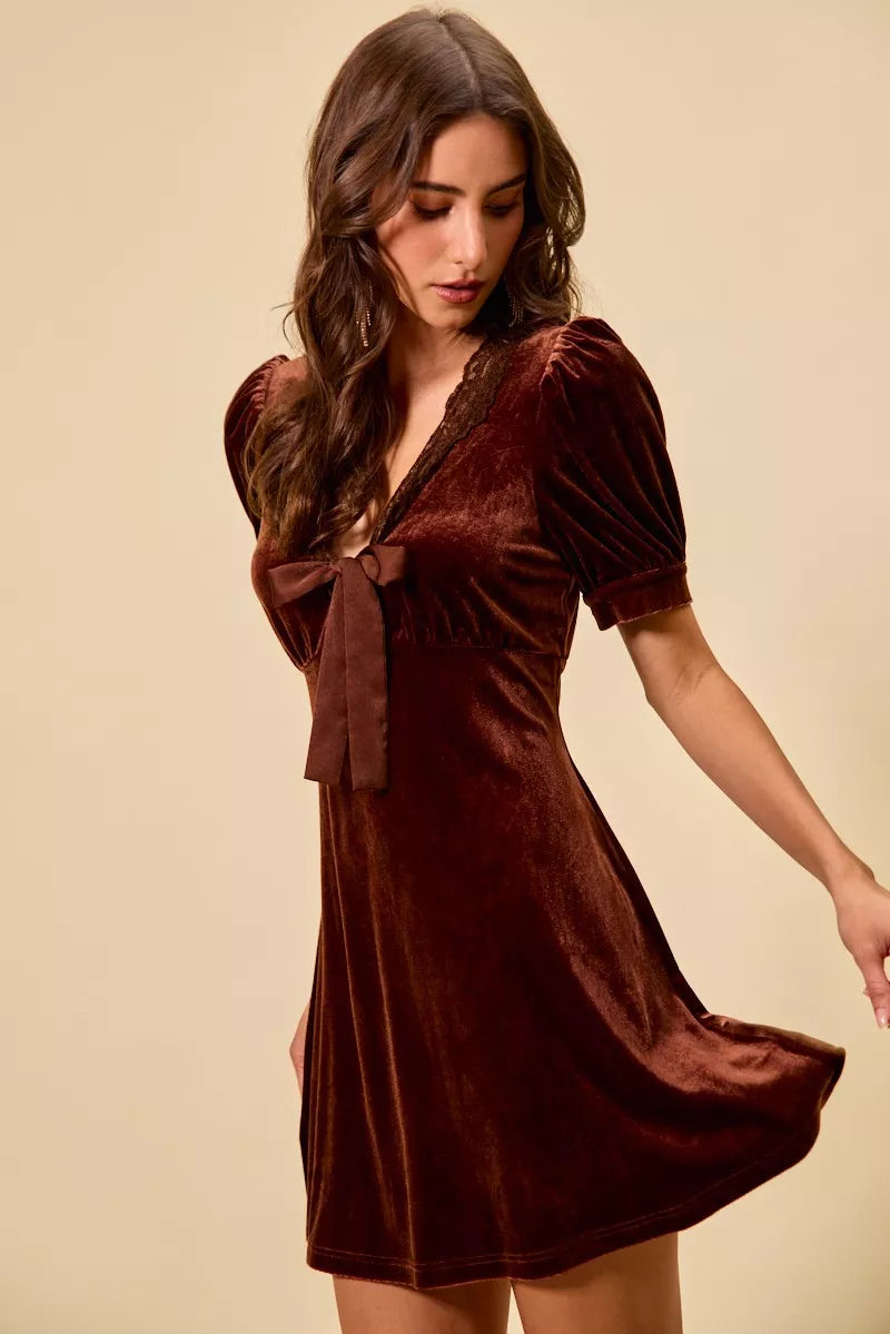 Burgundy velvet mini dress with lace V-neck, bow detail, and short sleeves.