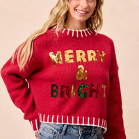 Red knit Christmas sweater with sequin “Merry & Bright” lettering and striped rib trim
