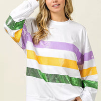 White pullover sweatshirt with sequin purple, yellow, and green stripes and round neckline
