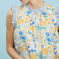 Floral babydoll dress close-up, gathered ruffled neckline, blue and yellow botanical print