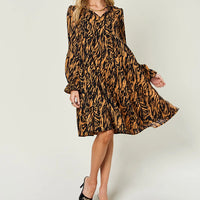 Caramel and black printed swing dress with long sleeves and ruffled skirt