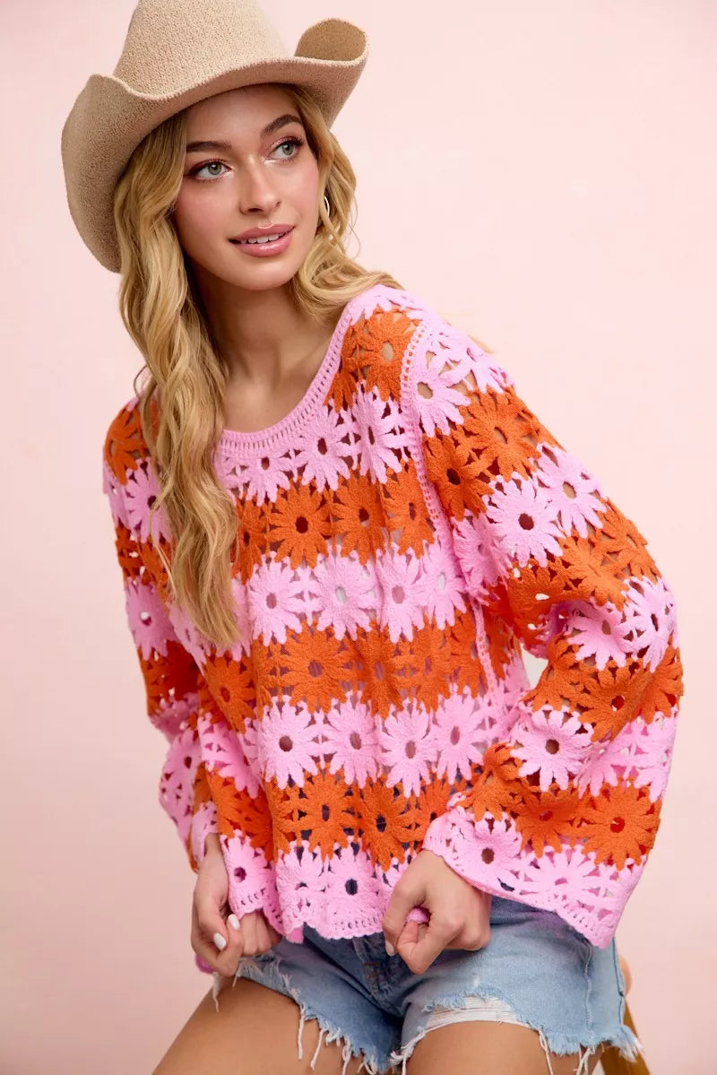 Orange and pink floral crochet top, long sleeves with openwork flower motifs.