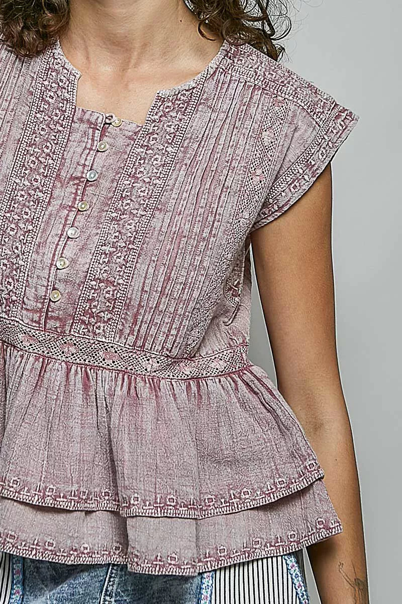 Pink sleeveless embroidered neckline blouse with button placket and pintuck front detail.