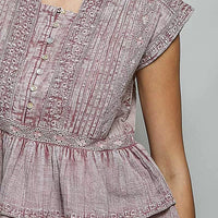 Pink sleeveless embroidered neckline blouse with button placket and pintuck front detail.
