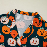 Close-up of pumpkin-printed short-sleeve collar and fabric in dark green and orange