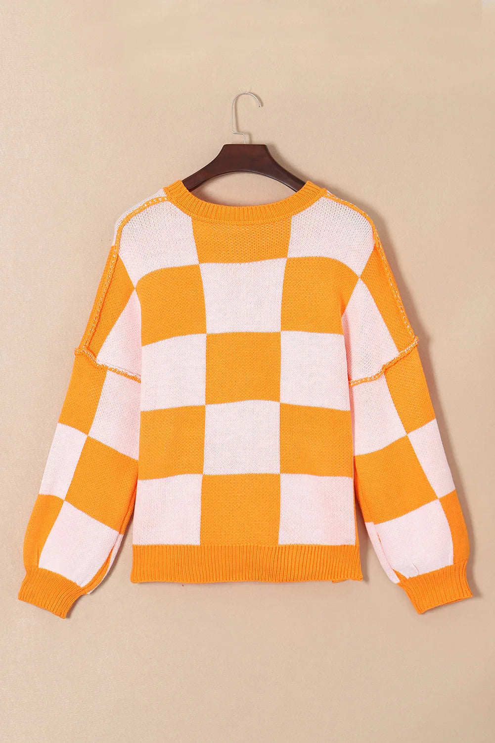 Orange and white checkered long-sleeve sweater with ribbed round neckline