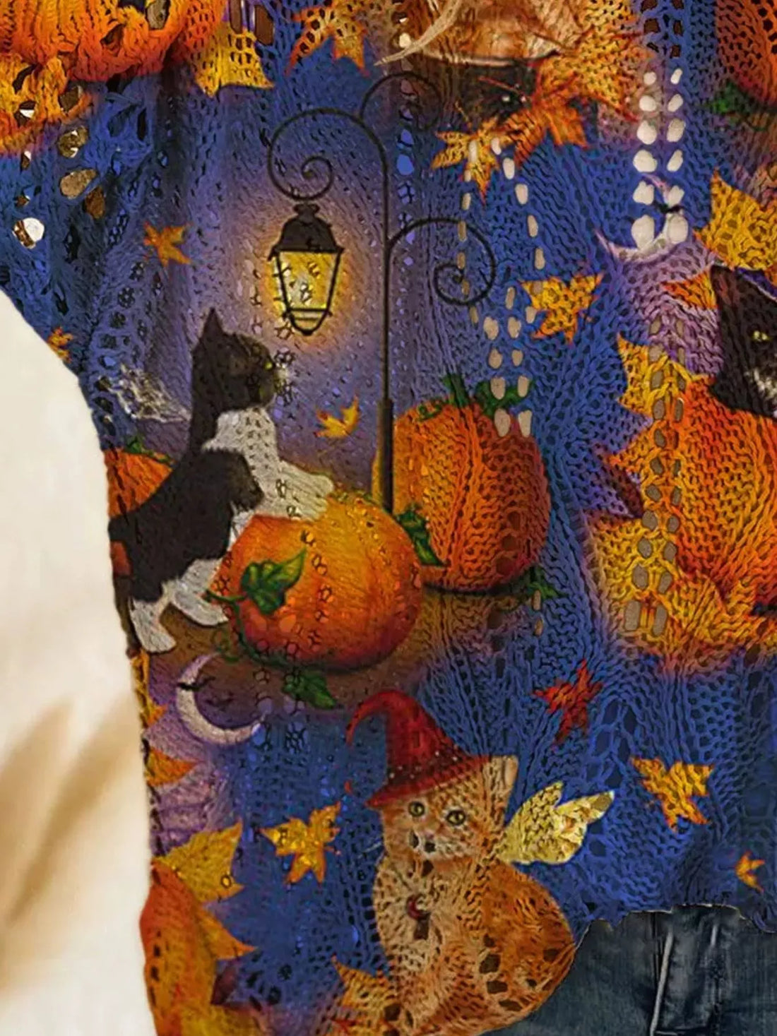 Plus size loose knit cover-up close-up with blue and purple fabric and orange pumpkin graphic.