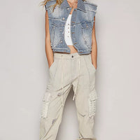 Light wash denim sleeveless vest with asymmetrical button front and raw hem