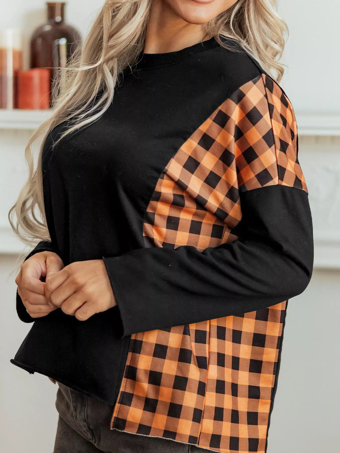Black long-sleeve top with orange plaid sleeve panels and pumpkin face detail
