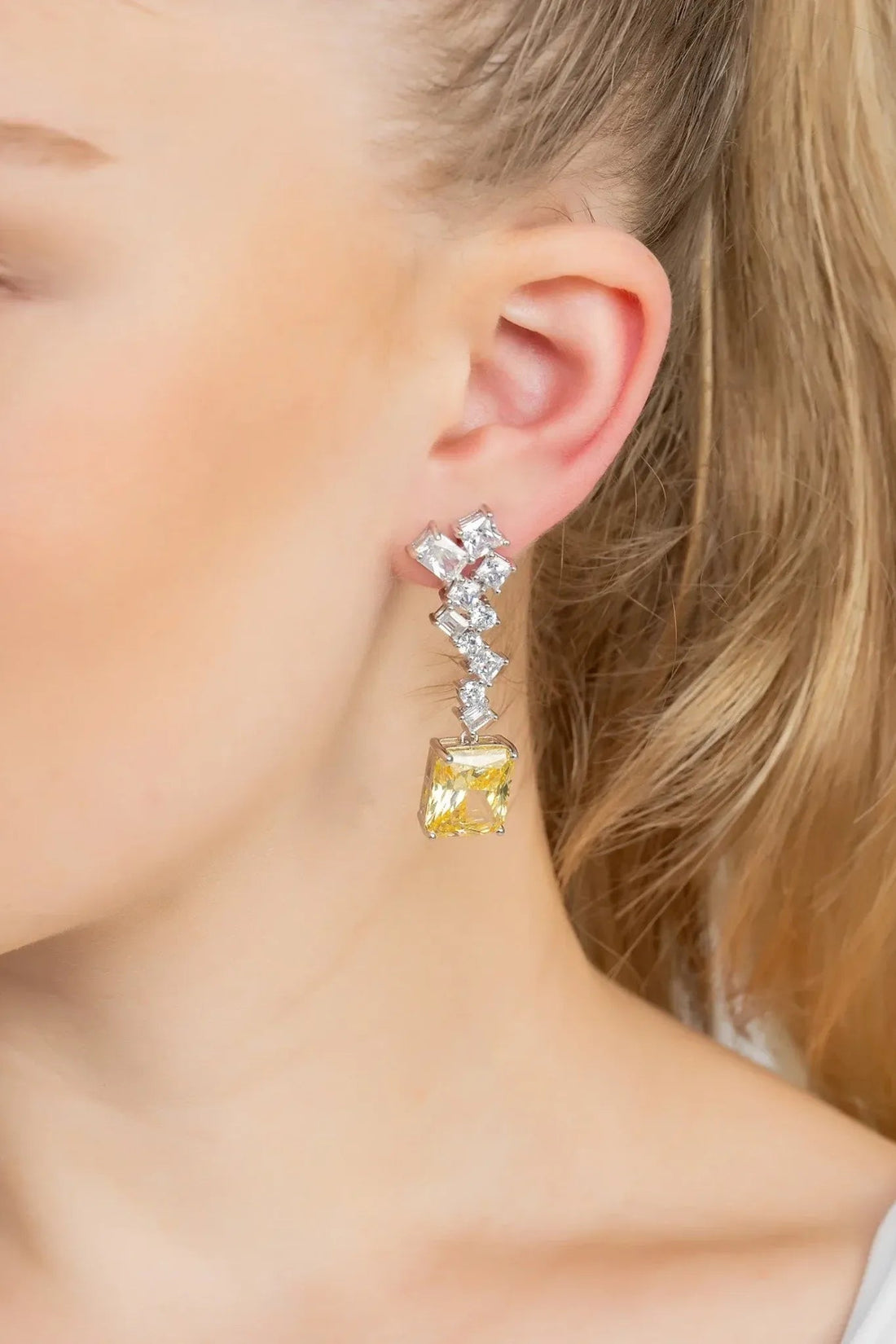 Silver drop earrings on ear: square lemon-yellow topaz with white crystal drop