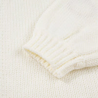 Close-up of off-white knit cardigan sleeve cuff with ribbed knit trim.